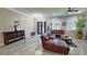 Open concept living room with porcelain floors, large leather sofa, and modern fixtures at 2891 S Rainbow Ave, Pahrump, NV 89048