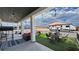 Inviting covered patio with ceiling fans, outdoor furniture, and adjacent turf area perfect for entertaining and relaxation at 2891 S Rainbow Ave, Pahrump, NV 89048