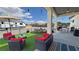 Beautifully arranged outdoor patio area on artificial turf featuring a dining table and seating, lounge set, and a recreational vehicle at 2891 S Rainbow Ave, Pahrump, NV 89048