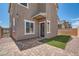 Walled backyard with artificial turf and pavers leading to a door at 363 Silva Pl, Henderson, NV 89011