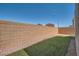 Long, narrow backyard area with artificial turf and a high brick wall at 363 Silva Pl, Henderson, NV 89011