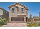 Two-story home featuring a brick-paved driveway and a two-car garage with stone accents at 363 Silva Pl, Henderson, NV 89011