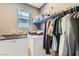 Bright and clean laundry room with modern washer and dryer, shelving and a hanging rod for clothes at 363 Silva Pl, Henderson, NV 89011
