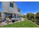 Spacious backyard featuring a manicured lawn, patio seating, and lush landscaping for outdoor enjoyment at 396 Blackstone River Ave, Las Vegas, NV 89148