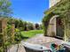 A quaint backyard with lush green grass and access to the home from a brick and stone tiled patio at 396 Blackstone River Ave, Las Vegas, NV 89148