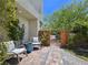 Cozy outdoor seating area with gray chairs, stone flooring, lush plants, and a private gated entrance at 396 Blackstone River Ave, Las Vegas, NV 89148