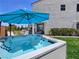 Backyard with a luxurious hot tub, comfortable seating, and manicured lawn for ultimate relaxation at 396 Blackstone River Ave, Las Vegas, NV 89148
