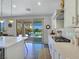 Modern kitchen featuring white cabinetry, a central island, and access to an outdoor patio through sliding glass doors at 396 Blackstone River Ave, Las Vegas, NV 89148