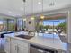 Bright kitchen with stainless steel appliances, large island, and sliding doors to a landscaped backyard at 396 Blackstone River Ave, Las Vegas, NV 89148