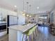 Open concept kitchen features modern stainless steel appliances, an island with seating, and hardwood floors at 396 Blackstone River Ave, Las Vegas, NV 89148