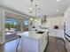 Bright kitchen with an island featuring sink and dishwasher, pendant lighting and sliding door to outdoor space at 396 Blackstone River Ave, Las Vegas, NV 89148