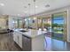 Open-concept kitchen with a center island, stainless steel appliances, and views of the outdoor living area at 396 Blackstone River Ave, Las Vegas, NV 89148