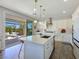 Bright kitchen with an island featuring sink and dishwasher, pendant lighting and sliding door to outdoor space at 396 Blackstone River Ave, Las Vegas, NV 89148