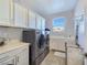 Well-lit laundry room with gray washer and dryer set, sink, and storage cabinets at 396 Blackstone River Ave, Las Vegas, NV 89148