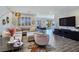 Bright, open-concept living room with neutral furniture, recessed lighting, and wood look tile flooring at 396 Blackstone River Ave, Las Vegas, NV 89148