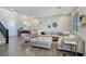 Open living space with wood-look tile, plush sectional, modern decor and natural light from window with shutters at 396 Blackstone River Ave, Las Vegas, NV 89148