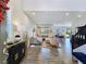 Bright, open-concept living room with neutral furniture, recessed lighting, and wood look tile flooring at 396 Blackstone River Ave, Las Vegas, NV 89148