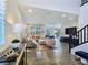 Bright, open-concept living room with neutral furniture, recessed lighting, and wood look tile flooring at 396 Blackstone River Ave, Las Vegas, NV 89148