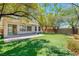 Beautiful backyard with covered patio, artificial grass, mature trees, and a seamless indoor-outdoor living experience at 42 Glade Water Dr, Henderson, NV 89052