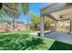Large backyard boasts a covered patio, low-maintenance turf, and shade trees, ideal for relaxation and entertaining at 42 Glade Water Dr, Henderson, NV 89052