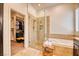 Well-lit bathroom featuring a glass shower, soaking tub, dark cabinets, and a view to the walk-in closet at 42 Glade Water Dr, Henderson, NV 89052