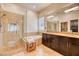 Bathroom featuring walk-in shower, soaking tub, granite counters, and dark cabinets at 42 Glade Water Dr, Henderson, NV 89052