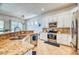 Updated kitchen with granite countertops, stainless steel appliances, and a view to the adjacent dining room at 42 Glade Water Dr, Henderson, NV 89052