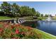 Scenic view of a pond with a stone bridge and fountain, surrounded by greenery at 42 Glade Water Dr, Henderson, NV 89052