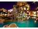 Stunning pool with rock waterfall feature, palm trees, and lush landscaping at night at 4200 S Valley View Blvd # 3074, Las Vegas, NV 89103