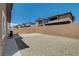Empty backyard with a concrete patio, gravel area, and tall brick wall at 4240 Spring Storm Ave, North Las Vegas, NV 89081