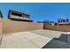 Empty backyard with a concrete patio, gravel area, and tall brick wall at 4240 Spring Storm Ave, North Las Vegas, NV 89081