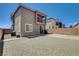 Backyard with a concrete patio, gravel area, and tall brick wall with the house in the background at 4240 Spring Storm Ave, North Las Vegas, NV 89081