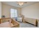 Bedroom with a crib, rocking chair, and soft gray carpet at 4240 Spring Storm Ave, North Las Vegas, NV 89081