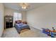A bedroom with gray carpet, a ceiling fan, and a window at 4240 Spring Storm Ave, North Las Vegas, NV 89081