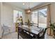 Cozy dining room area features a modern light fixture and natural light from the windows at 4240 Spring Storm Ave, North Las Vegas, NV 89081