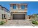 Two story home with a brick driveway, a two car garage and neutral colored stucco at 4240 Spring Storm Ave, North Las Vegas, NV 89081