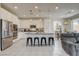 Bright kitchen features stainless steel appliances, white cabinets, and a large island with seating at 4240 Spring Storm Ave, North Las Vegas, NV 89081