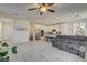Open concept living room flowing to the kitchen features a plush gray sectional sofa at 4240 Spring Storm Ave, North Las Vegas, NV 89081