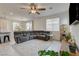 Spacious living room features a plush gray sectional sofa, ceiling fan, and tile flooring at 4240 Spring Storm Ave, North Las Vegas, NV 89081