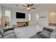 Inviting living room with tile flooring, ceiling fan, and cozy sectional sofa at 4240 Spring Storm Ave, North Las Vegas, NV 89081