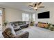 Comfortable living room features plush sectional sofa, ceiling fan, and large windows at 4240 Spring Storm Ave, North Las Vegas, NV 89081
