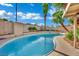 View of the sparkling backyard pool and palm trees against a sunny sky at 4637 Balfour Dr, Las Vegas, NV 89121