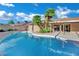 Sunny backyard features a sparkling pool, patio, palm trees, and lush landscaping at 4637 Balfour Dr, Las Vegas, NV 89121