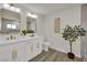 Bright bathroom featuring double sinks with gold fixtures and wood-look floors at 4637 Balfour Dr, Las Vegas, NV 89121