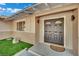 Inviting front door with decorative glass accents and modern sconces, framed by manicured landscaping at 4637 Balfour Dr, Las Vegas, NV 89121