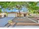 Charming home with desert landscaping, mature tree, and inviting double-door entrance at 4637 Balfour Dr, Las Vegas, NV 89121