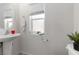 Half bathroom with white pedestal sink and window allowing natural light at 4976 Quiet Morning St, Las Vegas, NV 89122