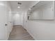 Hallway with wood-look floors, white walls, recessed lighting, white doors, and a large mirror at 4976 Quiet Morning St, Las Vegas, NV 89122