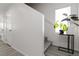 Bright hallway leading to stairs with modern plant stand in a neutral palette at 4976 Quiet Morning St, Las Vegas, NV 89122