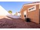 View of backyard with rock landscaping, white fence, and exterior of house at 5045 Bayberry Crest St, North Las Vegas, NV 89031